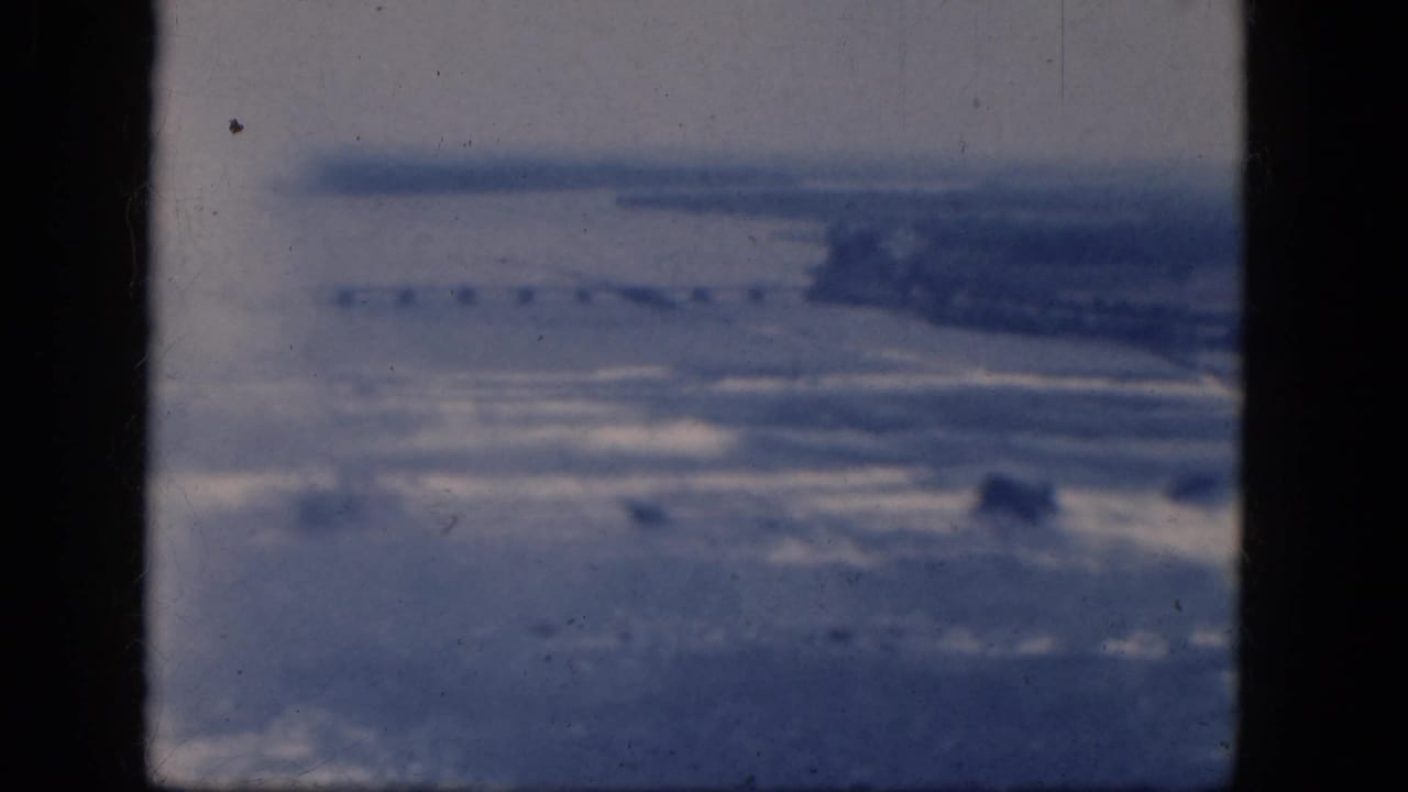 Distant misty landscape with water, shoreline, and a possible bridge span.