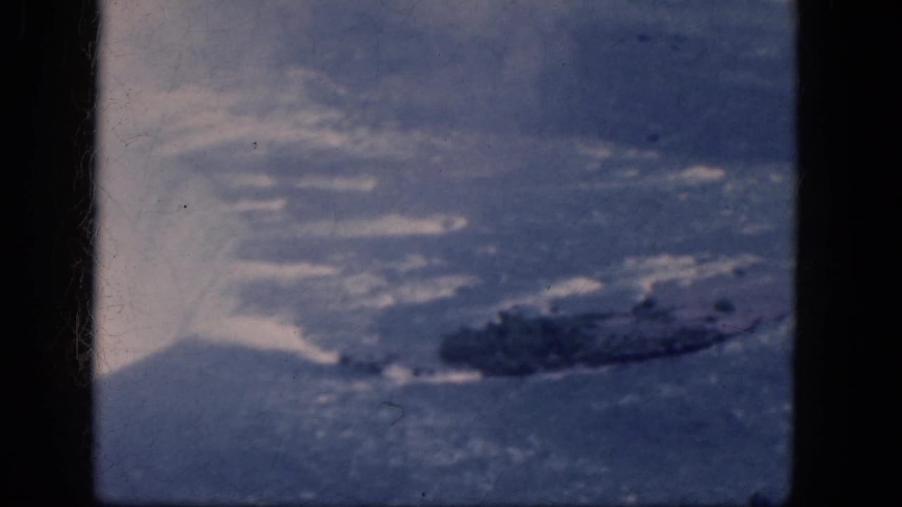 Aerial 8mm view of Niagara Falls, Canada, with mist lifting from the falls and a dark rocky island in the water.
