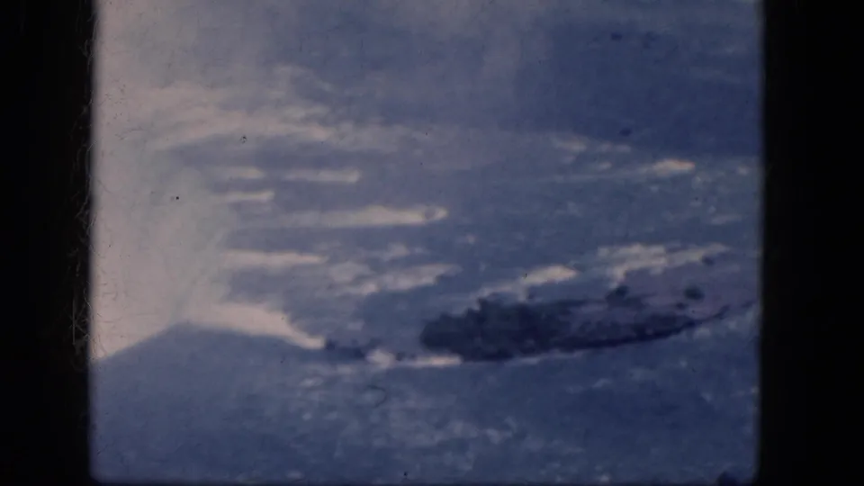 Aerial 8mm view of Niagara Falls, Canada, with mist lifting from the falls and a dark rocky island in the water.
