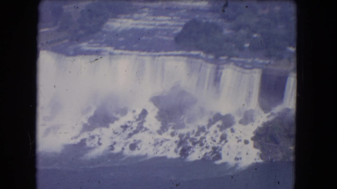 Waterfall cascade seen from above with mist and turbulent water at the base.