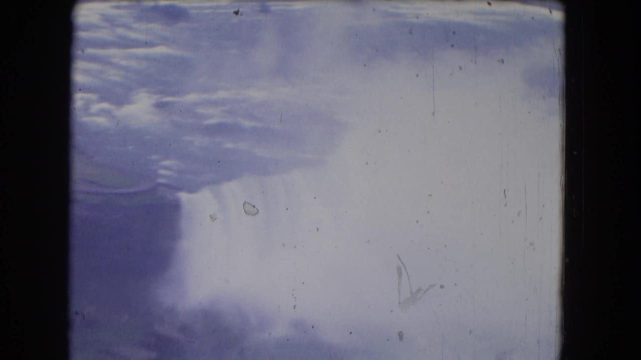 Wide view of Niagara Falls with pale mist and dark film borders.
