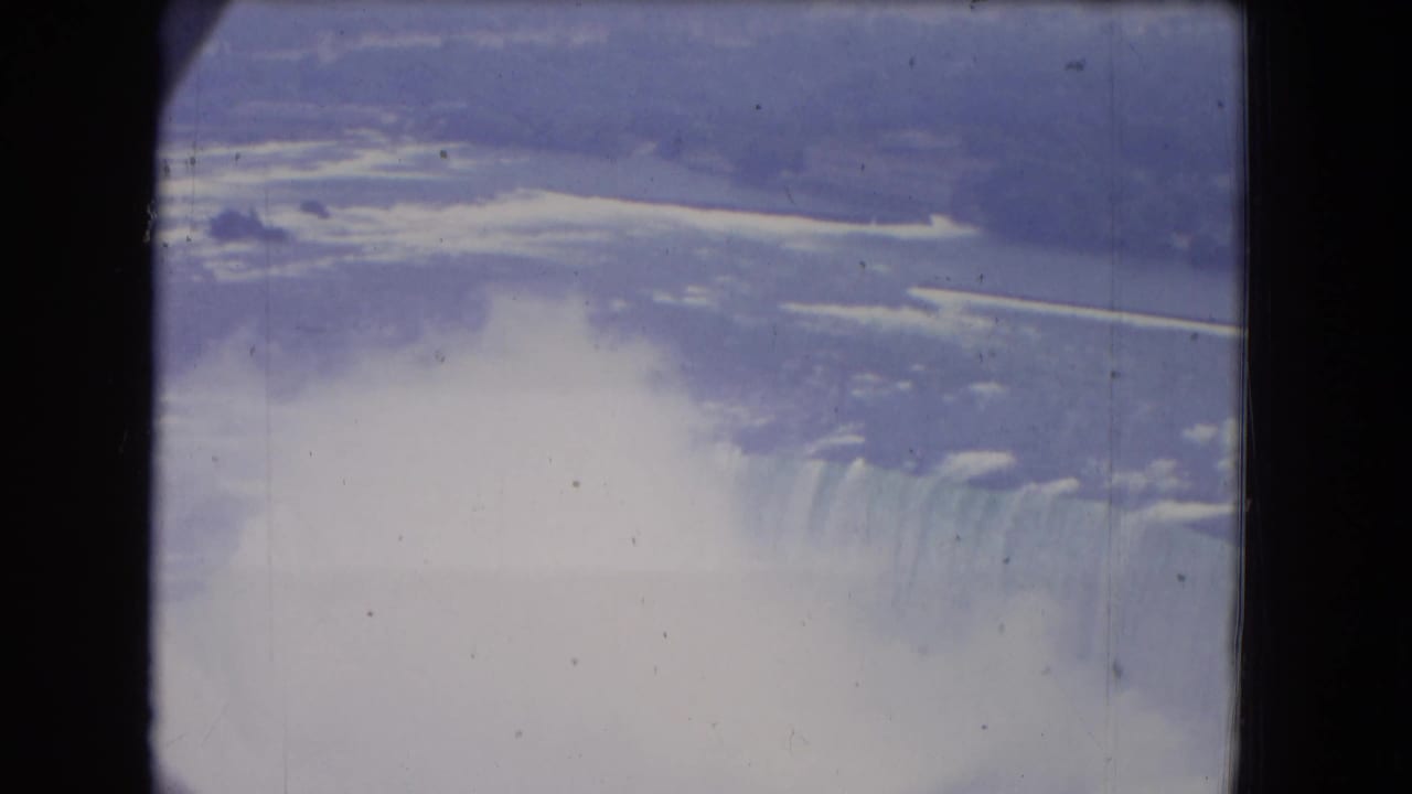 Niagara Falls and mist seen from above through dark vertical framing.