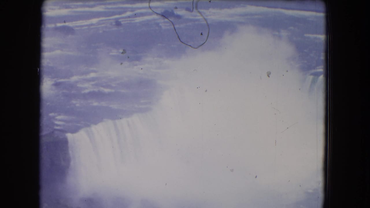 Niagara Falls in 1964 home-movie footage, with mist blooming over the cascade and visible film wear.