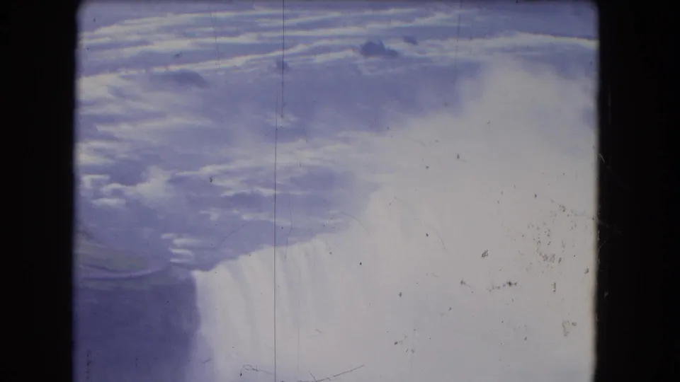 Elevated 1964 Niagara Falls view with churning water, mist and soft blue-purple 8mm color.