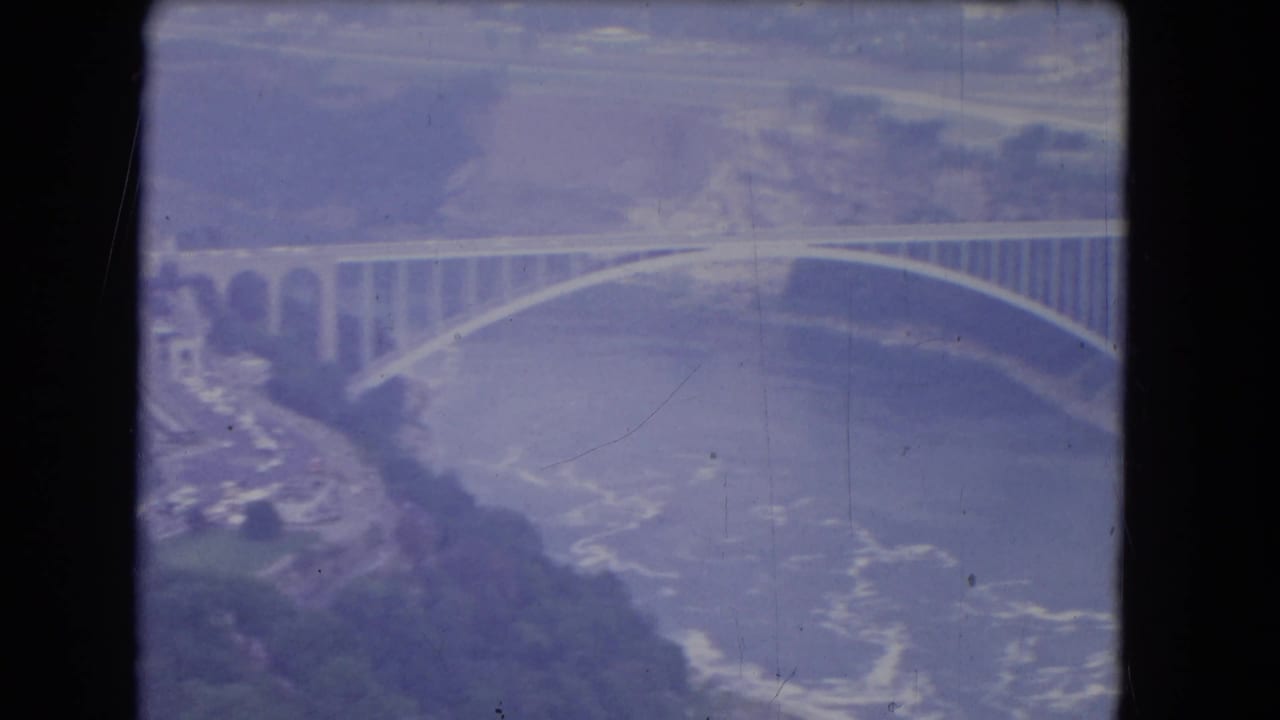 Aerial view of a large arched bridge spanning a wide river.