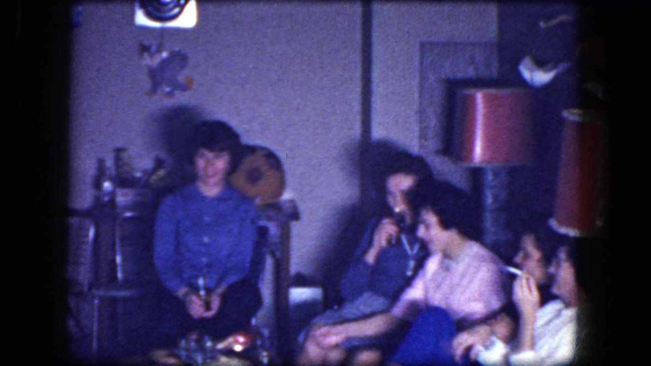 Several women sit together, one holding a drink and another smoking.