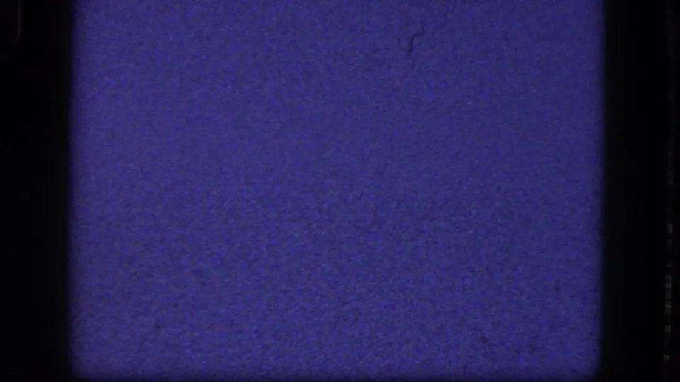 1964 8mm home-movie frame from the Niagara Falls reel showing a blue film field with dark gate edges and visible surface wear.