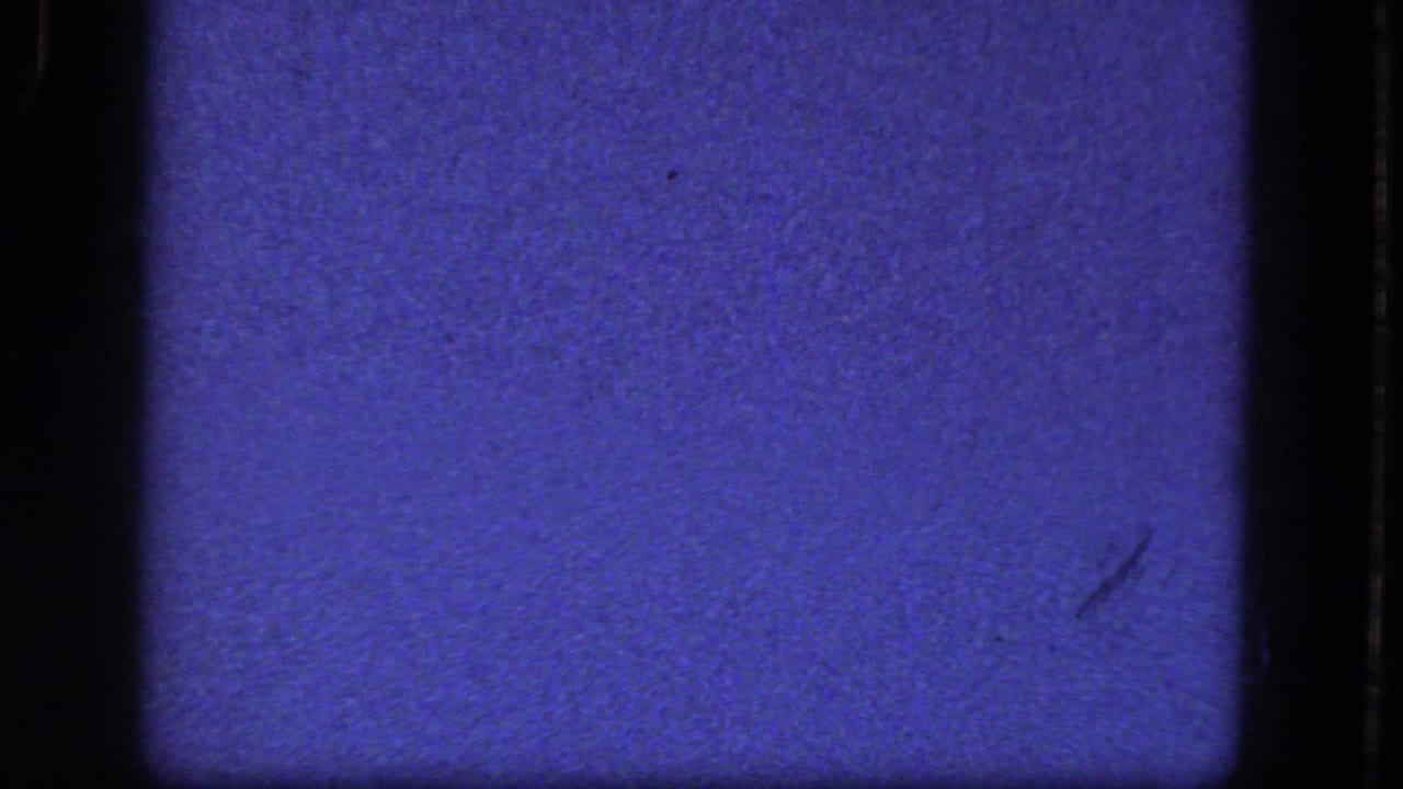 Blue textured film area with black side borders, dust marks, and a small scratch.