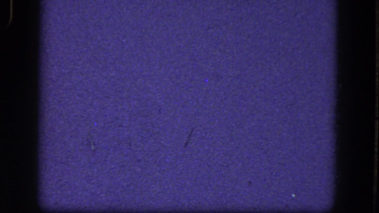 Purple-blue 8mm frame with dark film borders and no clear subject visible.
