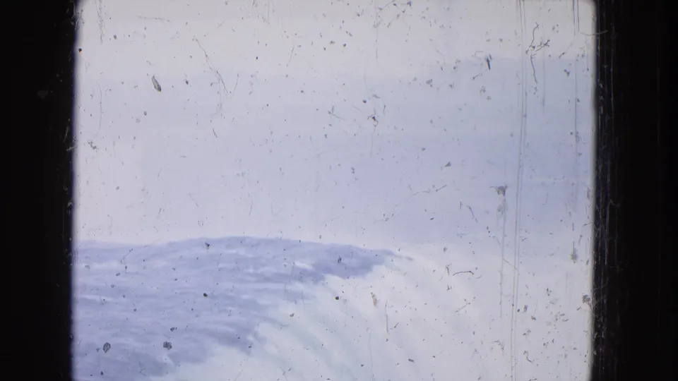 High-angle 1964 8mm view at Niagara Falls, with curved white water below, pale sky or mist above, and worn film texture visible.