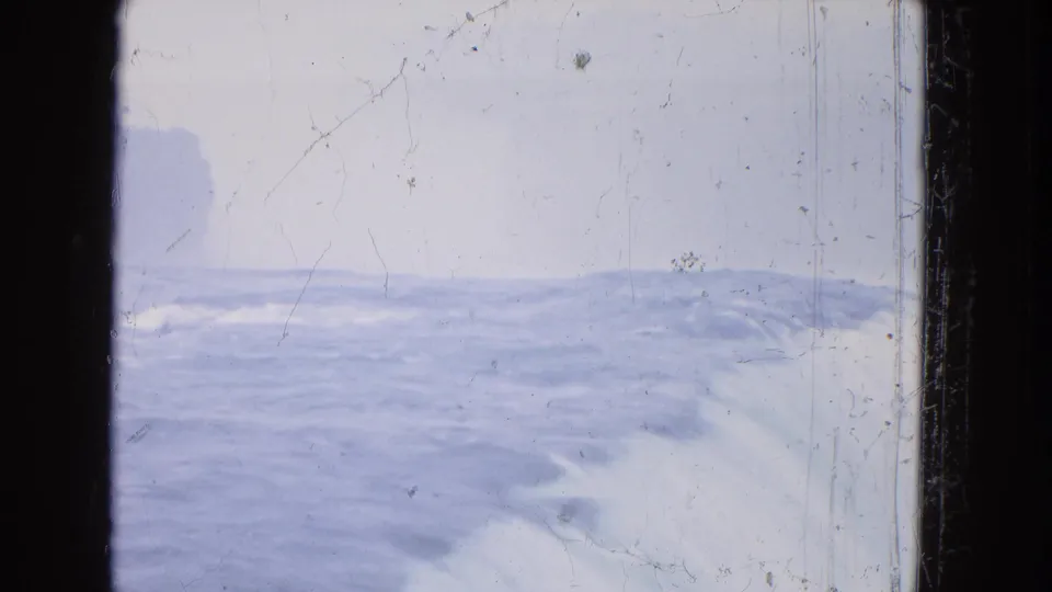 Distant 1964 8mm view of Niagara Falls water and mist, with dark gate edges and pronounced film wear.