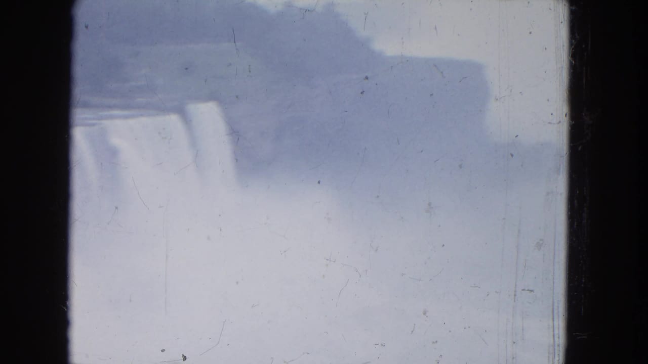 1964 8mm view of Niagara Falls fading into mist, with the cascade partly obscured by spray and exposure haze.