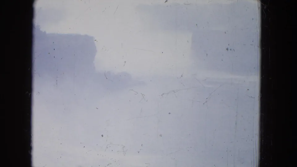 Misty Niagara Falls sky in a 1964 8mm frame, with faint cloud shapes and surface scratches.