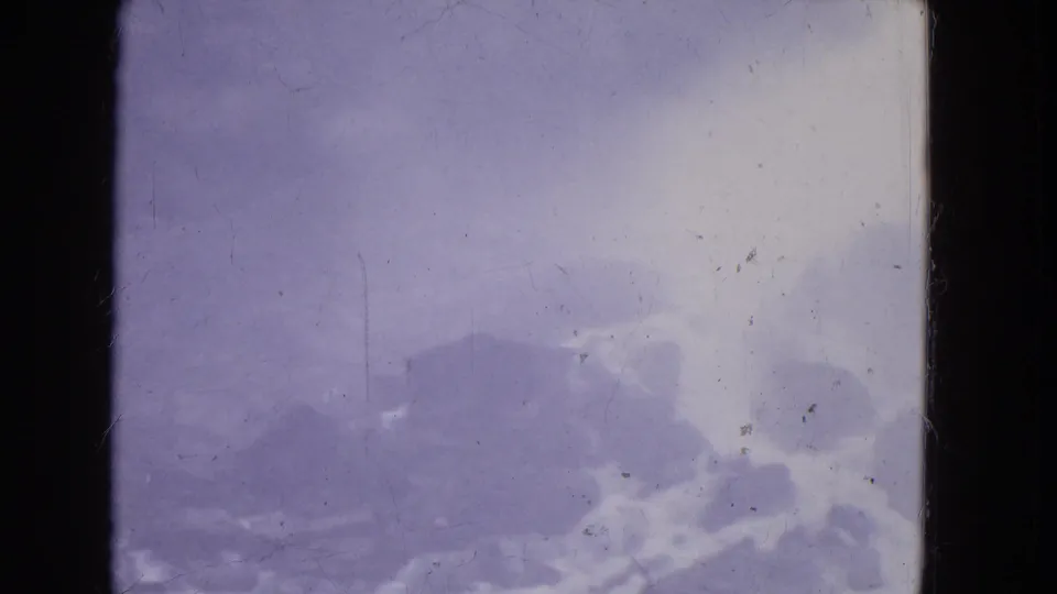 1964 Niagara Falls home-movie frame with low mist, dark cloud forms, and aged 8mm texture.