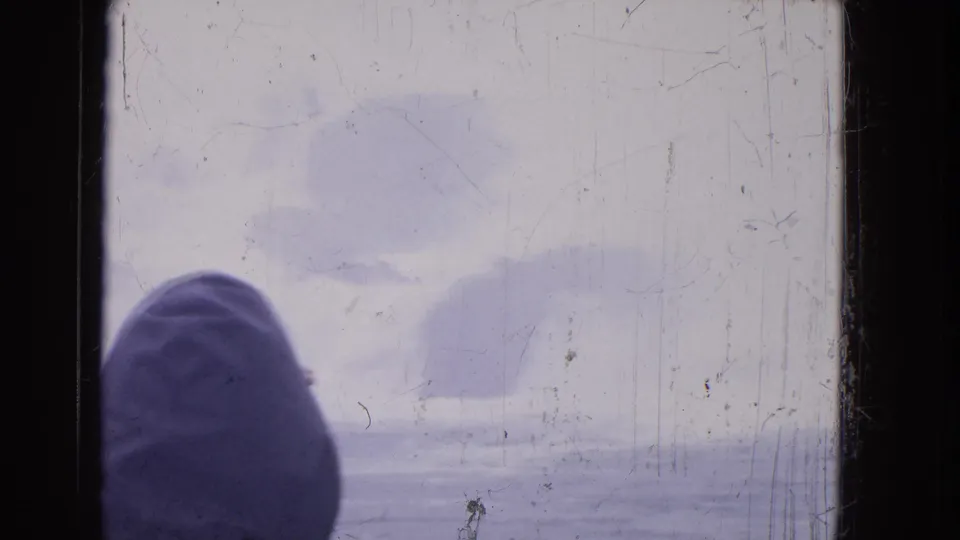 1964 Niagara Falls home-movie frame with a hooded person at a boat window, seen against misty water and a muted winter sky.