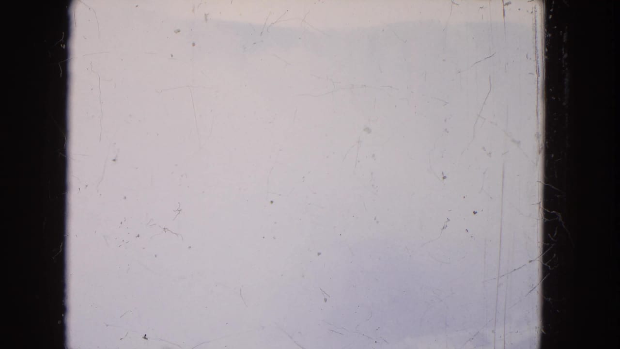 Overexposed or blank 8mm frame from the 1964 Niagara Falls reel, with dark film borders, dust, and scratches visible.