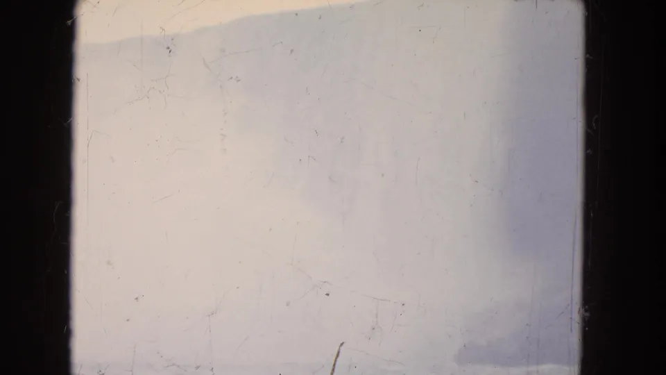 1964 Niagara Falls home-movie frame with pale mist, faint waterfall contours, and strong visible 8mm surface wear.