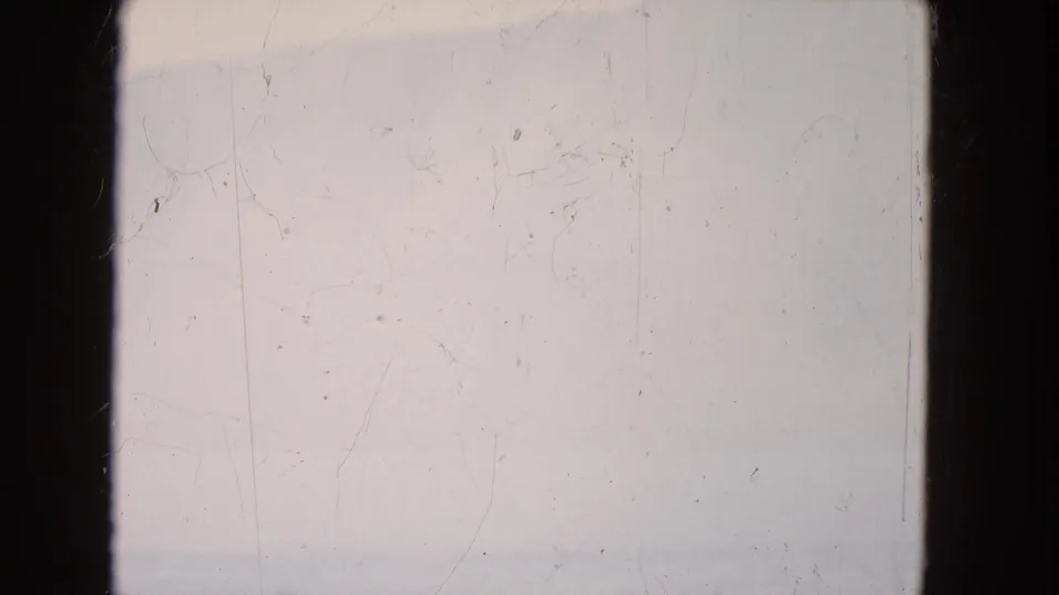 1964 8mm Niagara Falls footage showing a pale misty water view partly blocked by dark vertical frame edges.