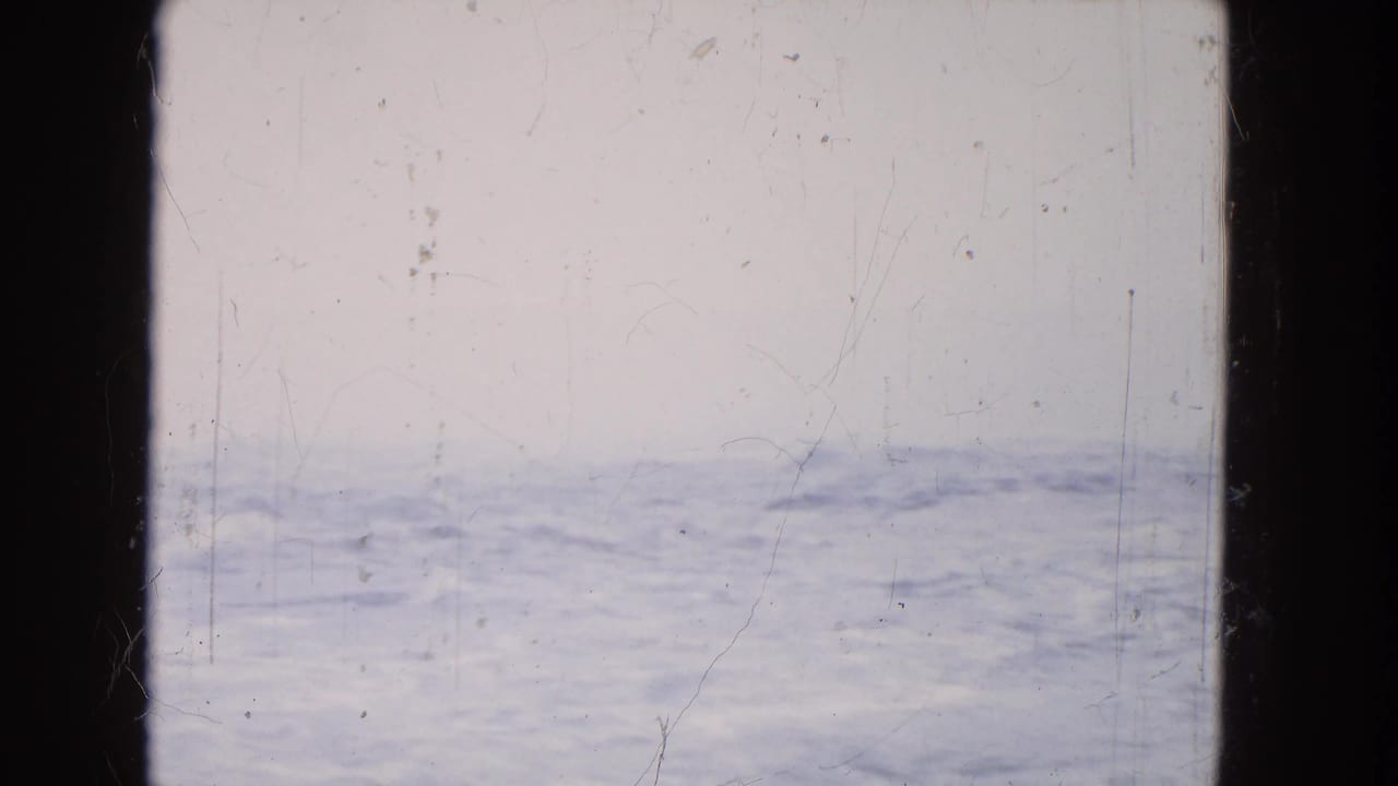 A soft, overexposed 8mm Niagara Falls water view shows blue-white froth, haze, scratches, and dark film borders.