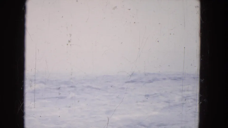 A soft, overexposed 8mm Niagara Falls water view shows blue-white froth, haze, scratches, and dark film borders.