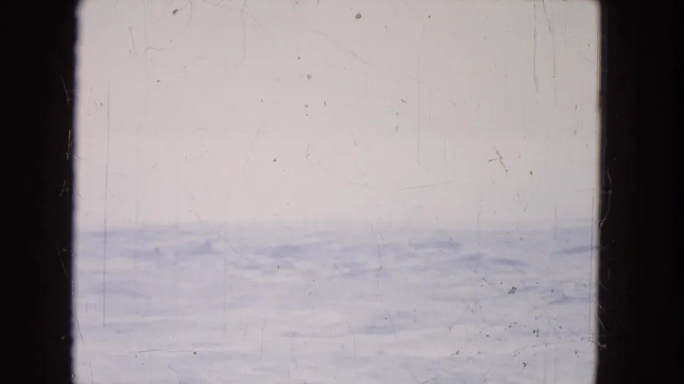 1964 8mm home-movie view near Niagara Falls showing pale water and a hazy horizon through dark window or film-frame borders.