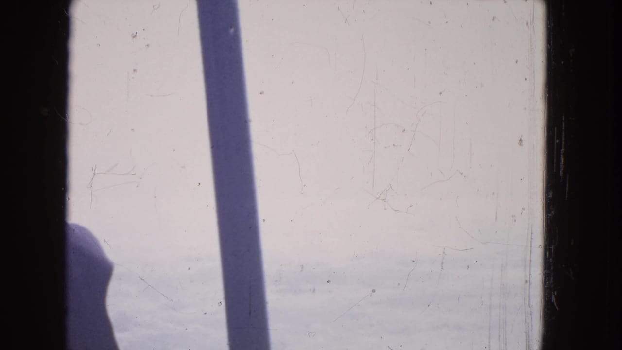 1964 boat-view footage near Niagara Falls showing bright water, a dark vertical shadow, and scratched 8mm film texture.