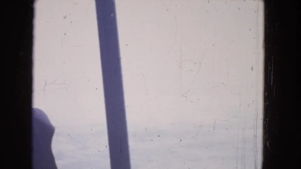 1964 boat-view footage near Niagara Falls showing bright water, a dark vertical shadow, and scratched 8mm film texture.