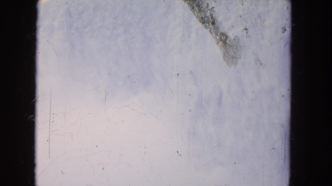 Aged 8mm frame from a 1964 Niagara Falls boat ride, showing pale moving water, dark borders, and visible scratches.