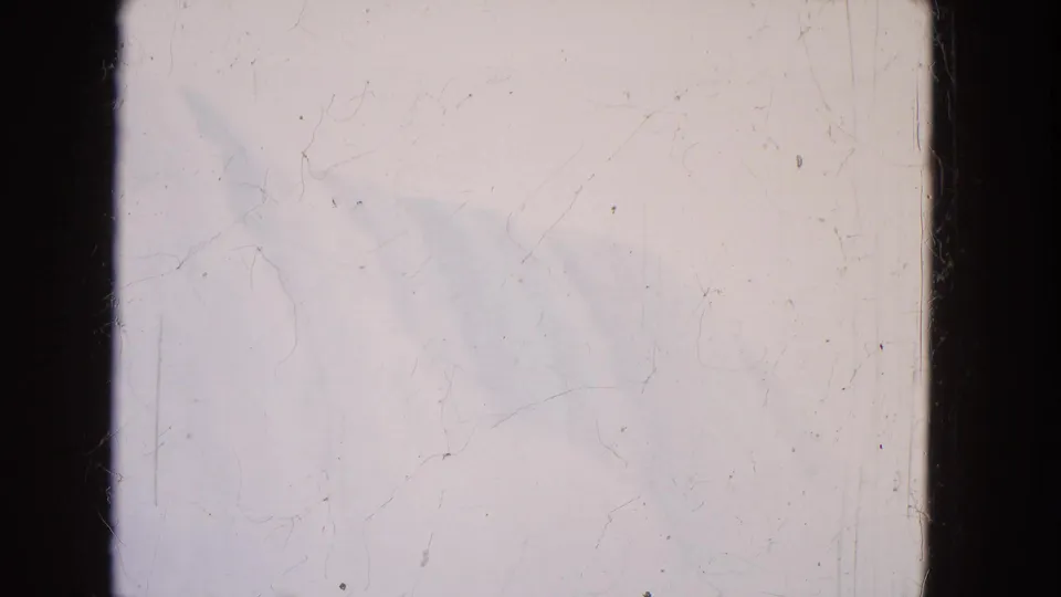 1964 8mm frame of Niagara Falls seen faintly through mist, with pale sky, water, and visible film wear.