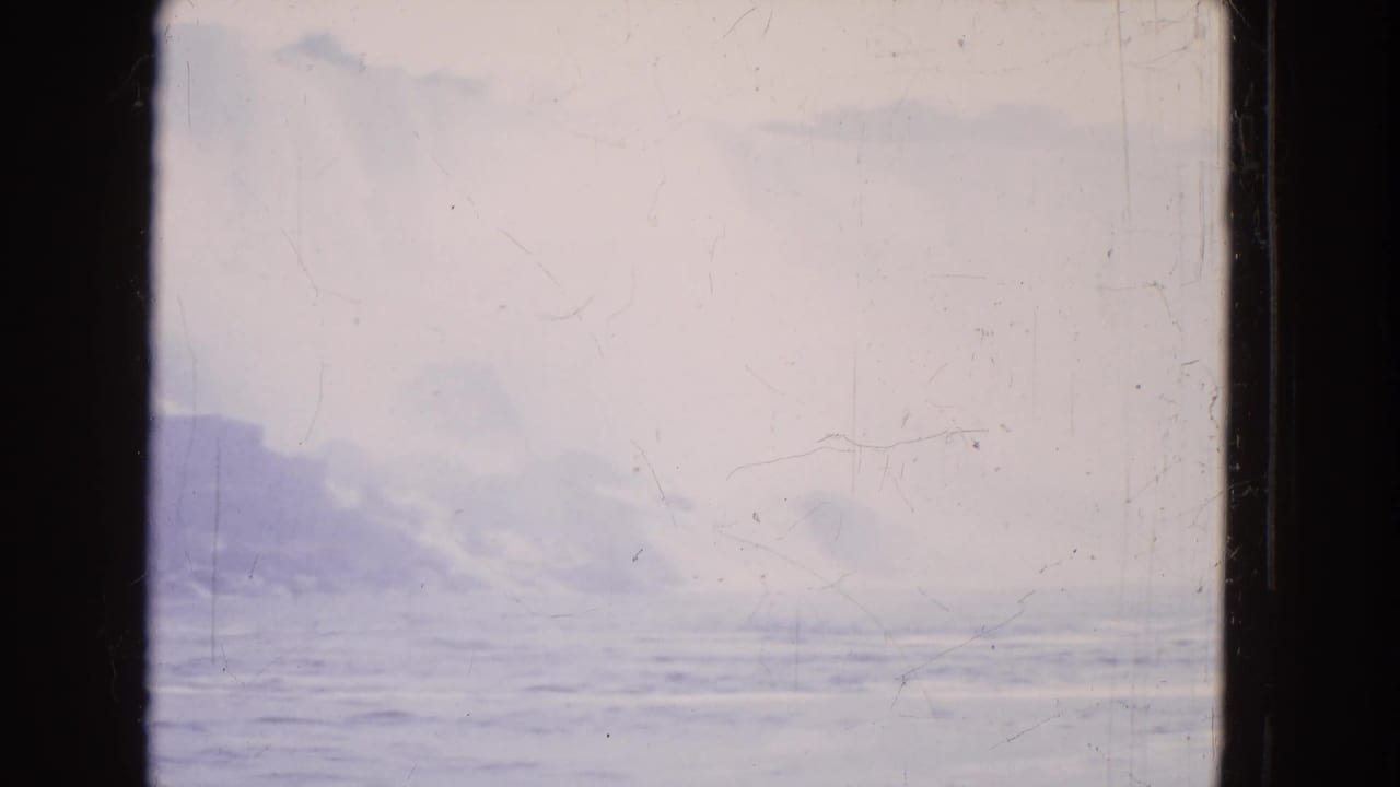 Faded 8mm frame showing misty water and low rock shapes at Niagara Falls from a moving boat viewpoint.