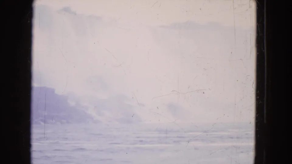 Faded 8mm frame showing misty water and low rock shapes at Niagara Falls from a moving boat viewpoint.