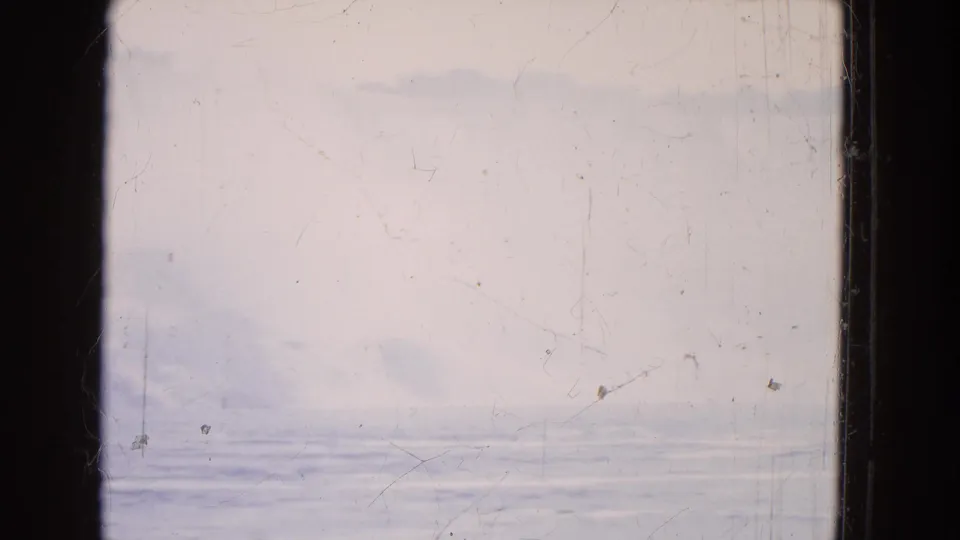 1964 8mm home-movie frame showing pale sky, distant haze, and rippled water, bordered by dark film or window edges.