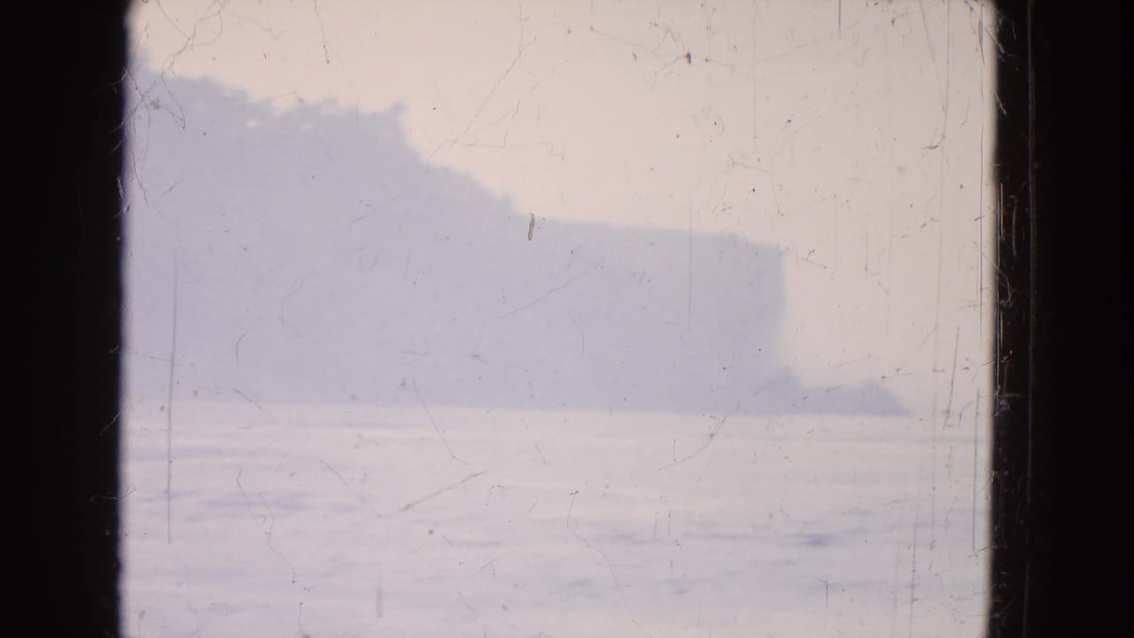Misty Niagara Falls-area water view on faded 8mm film, divided by a dark window or frame edge.