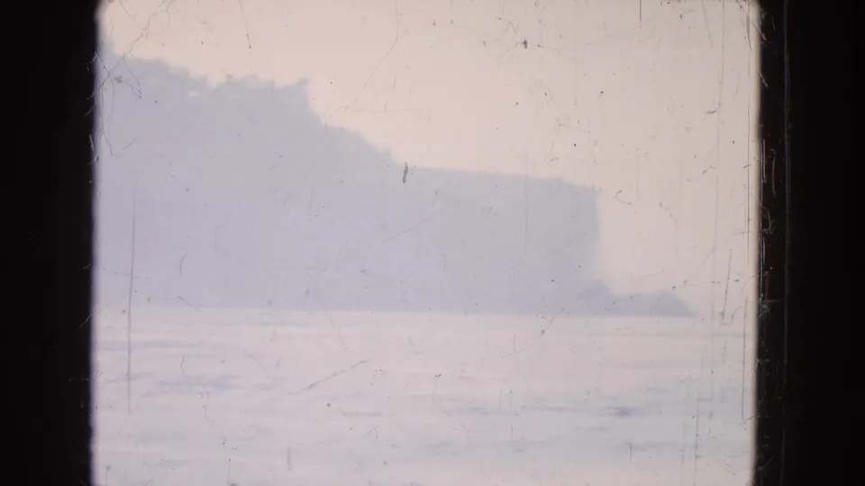 Misty Niagara Falls-area water view on faded 8mm film, divided by a dark window or frame edge.