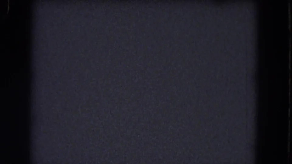 Dim blue-gray 8mm frame from the 1964 Niagara Falls reel with dark gate edging, grain, and faint surface scratches.