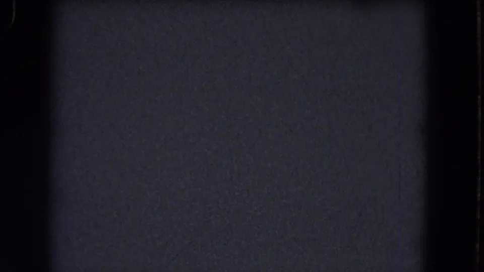 Dark blue-gray 8mm home-movie frame from the 1964 Niagara Falls reel, showing grain, scratches, and black film borders.