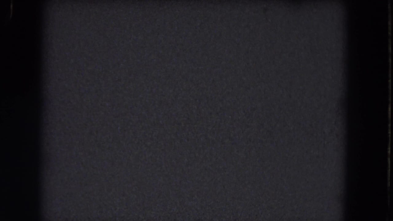 Dark gray static texture with black film borders and no visible subject.