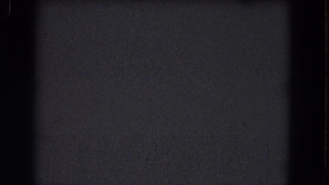 1964 8mm Niagara Falls frame showing a nearly blank dark screen with subtle grain, a black divider, and no identifiable subject.