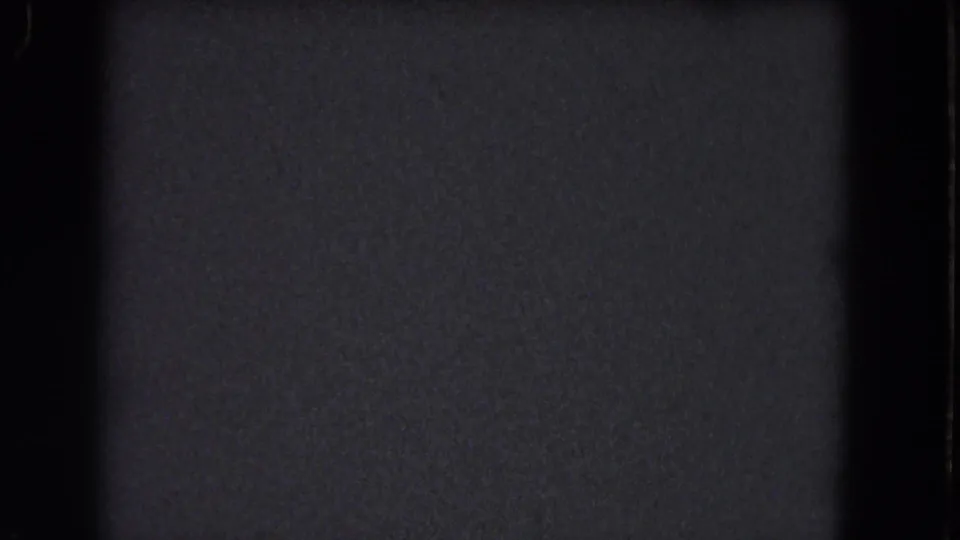 Dark 1964 8mm home-movie frame from the Niagara Falls reel, showing grain, gate edges, and no visible subject.