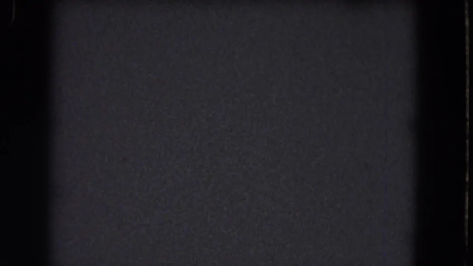 Underexposed 8mm frame from the 1964 Niagara Falls reel, with dark texture, grain, and no identifiable subject.