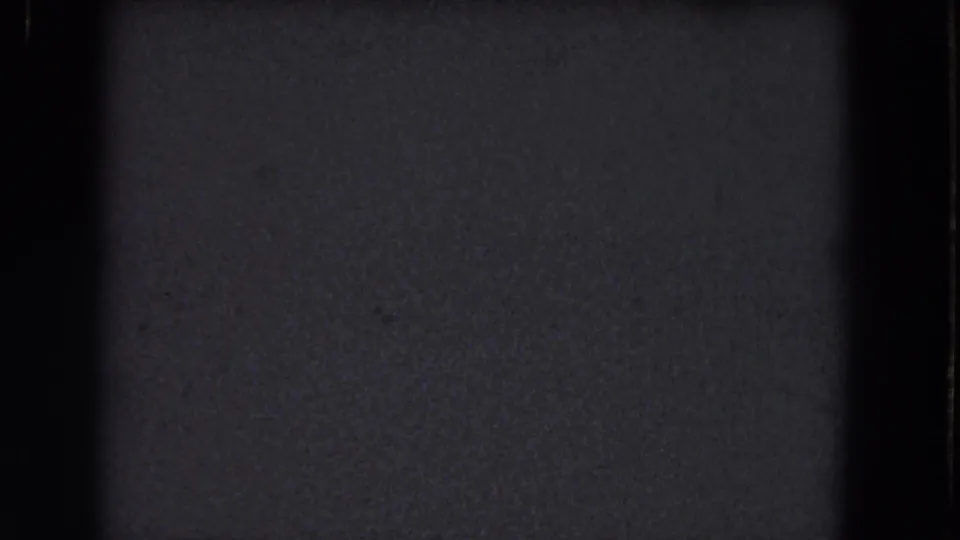 Nearly black final frame from the 1964 metadata-described reel, with visible film grain, dust, and gate-edge shading but no identifiable subject.