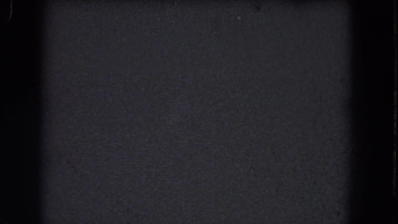 Dark textured film frame with black edges and no identifiable subject.