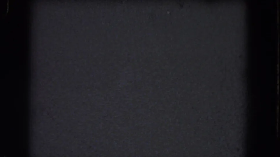 Dark 1964 8mm home-movie frame from the Niagara Falls metadata, showing grain, shadowed edges, and no visible people or landmarks.