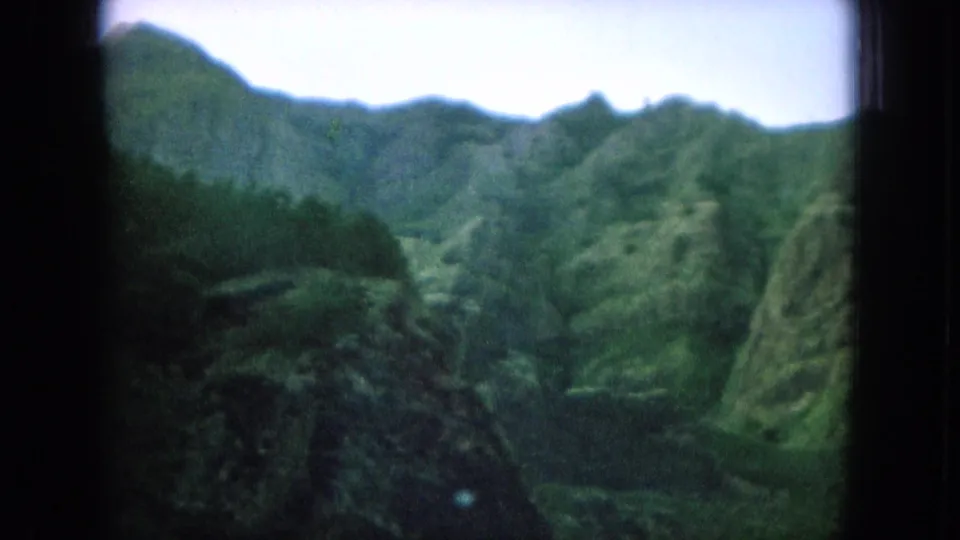 Lush Oahu mountain valley with layered green ridges captured in 1964 home-movie footage.