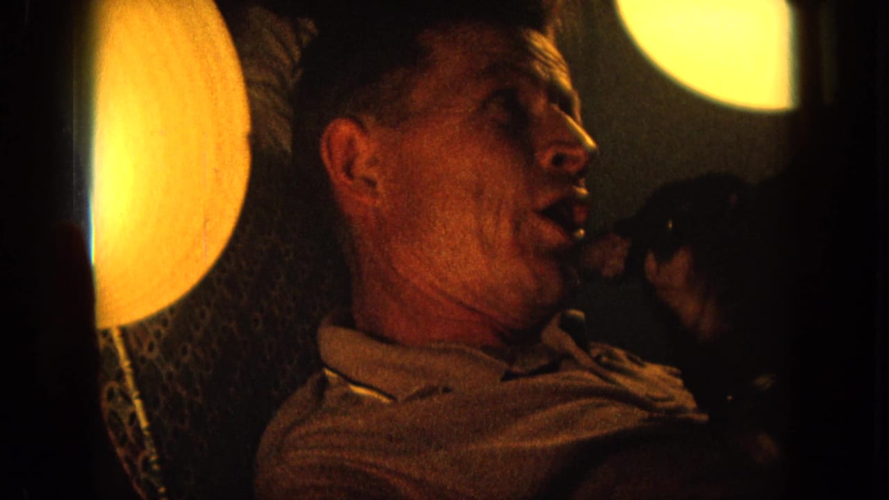 Side view of the singer with his mouth open near bright round lights.