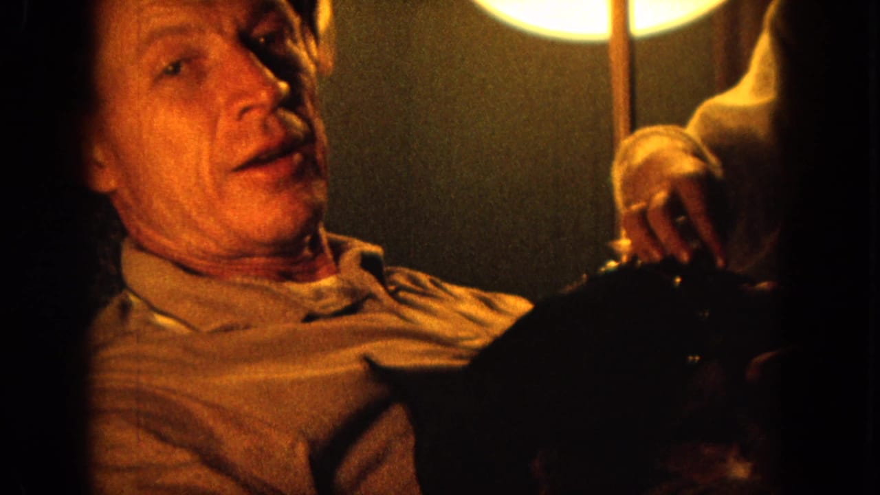 1964 Hawaii 8mm frame showing two adult men partly visible in a dim private interior lit by warm circular lamps.