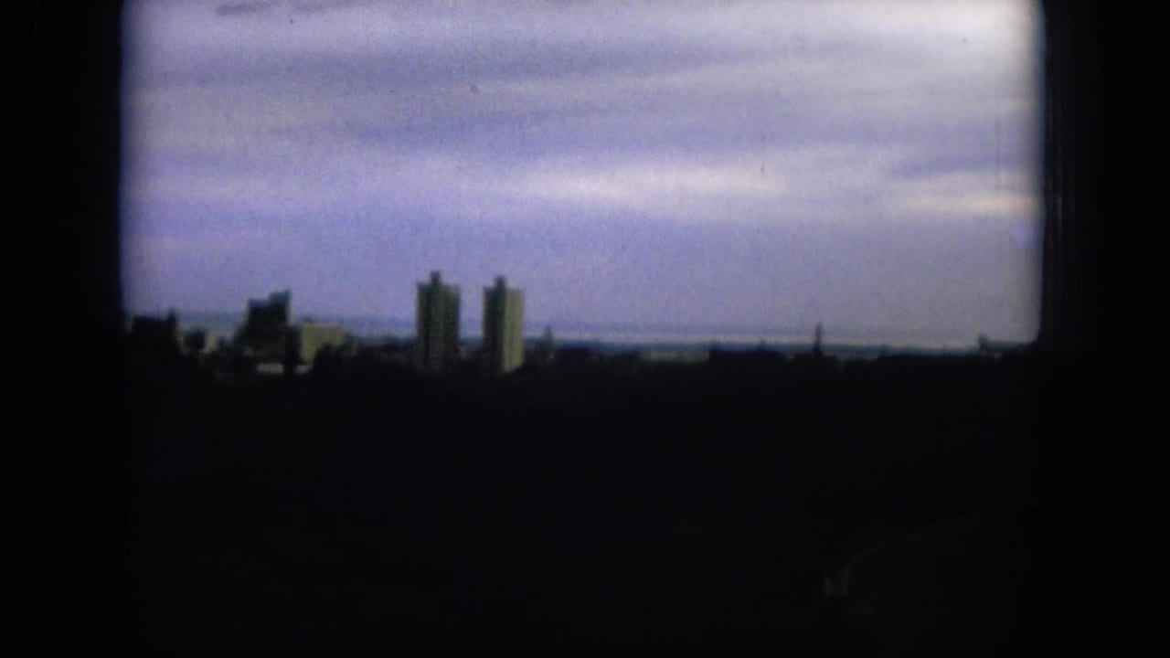 Distant towers and low buildings beneath overcast clouds.