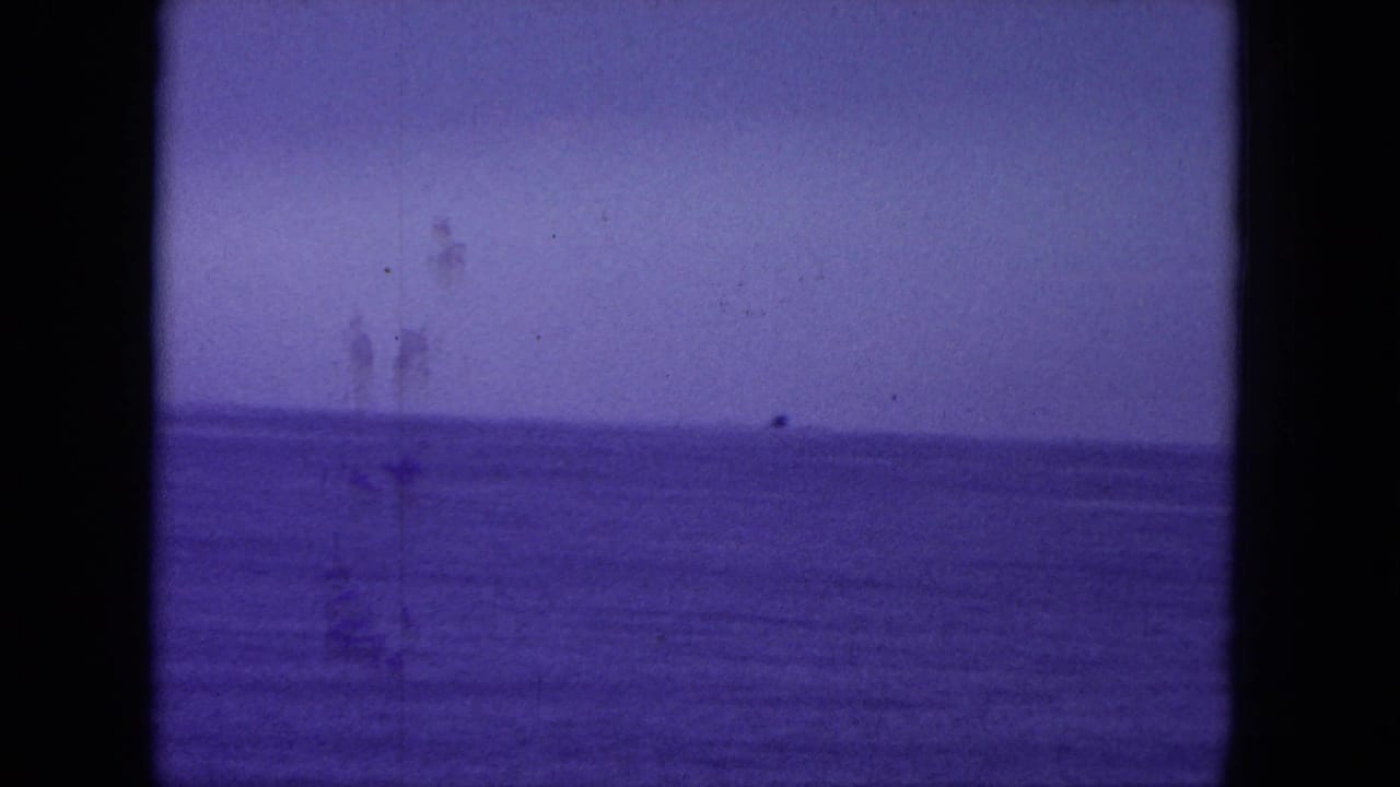 Purple-tinted ocean horizon framed by dark 8mm film borders.