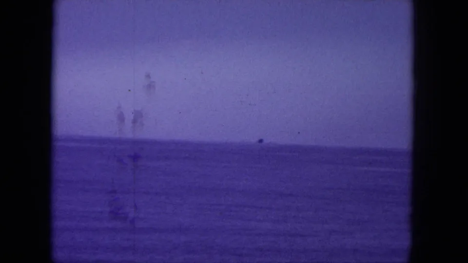 1964 Oahi, Hawaii 8mm frame showing calm open water and a distant horizon with heavy purple color shift and gate edges.