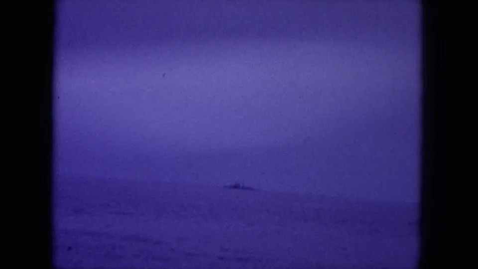 1964 Hawaii 8mm frame showing a small distant vessel on the horizon under a purple-blue dawn sky.